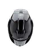 Kask Alpinestars Supertech R10 Solid, widok z góry, czarny karbon matowy i błyszczący, widoczna tekstura włókna węglowego po bokach, błyszcząca sekcja środkowa, aerodynamiczne otwory wentylacyjne oraz białe logo Alpinestars z przodu i z tyłu