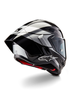 Kask Alpinestars Supertech R10 Element, czarny karbonowy srebrno-czarny z połyskiem, widok z tyłu pod kątem trzech czwartych ukazujący aerodynamiczny profil wyścigowy, błyszcząca skorupa z włókna węglowego z geometrycznymi szarymi i czarnymi grafikami, logo Alpinestars i czerwona wyściółka wewnętrzna