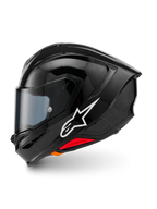 Kask Alpinestars S-R7 Solid, integralny kask motocyklowy, czarny z połyskiem, widok z lewego profilu z białym logo Alpinestars, aerodynamiczna skorupa ze zintegrowanym spojlerem, przyciemniany wizjer i czerwone akcenty systemu awaryjnego zwalniania.