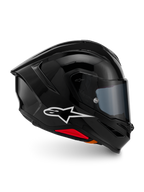 Kask Alpinestars S-R7 Solid, pełny kask motocyklowy, czarny błyszczący, widok z profilu z białym logo A-star, opływowa aerodynamiczna skorupa ze zintegrowanym spojlerem i czerwonymi akcentami u podstawy, zaprojektowany z myślą o wyścigach i sportowych osiągach