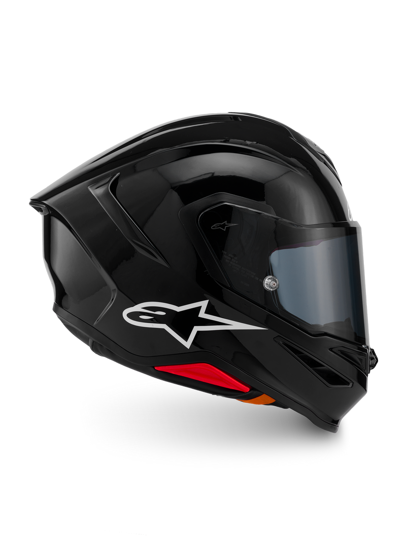 Kask Alpinestars S-R7 Solid, pełny kask motocyklowy, czarny błyszczący, widok z profilu z białym logo A-star, opływowa aerodynamiczna skorupa ze zintegrowanym spojlerem i czerwonymi akcentami u podstawy, zaprojektowany z myślą o wyścigach i sportowych osiągach