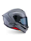 Alpinestars S-R7 Solid Helmet, integralny kask motocyklowy, szary błyszczący, widok z boku, błyszcząca szara aerodynamiczna skorupa z czarnym logo i czerwonymi akcentami u podstawy, wysokiej klasy sprzęt do wyścigów i jazdy sportowej