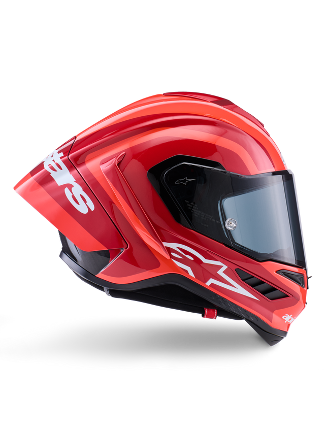 Kask Alpinestars Supertech R10 Arius, integralny kask wyścigowy, błyszczący czerwony i pomarańczowy, widok z boku prezentujący aerodynamiczny tylny spojler, białe logo Astars na szczęce i przezroczysty wizjer, zaprojektowany z myślą o wysokich osiągach na torze