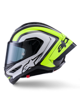 Kask Alpinestars Supertech R10 Arius, wyścigowy kask motocyklowy, czarny, srebrny i żółty fluo z połyskiem, widok z boku, wyposażony w aerodynamiczny tylny spojler, konstrukcję z włókna węglowego, wyraziste oznaczenia marki i przyciemniany wizjer.