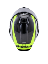 Kask Alpinestars Supertech R10 Arius, widok z góry, czarno-srebrny i żółty fluorescencyjny w połysku, skorupa z włókna węglowego z jaskrawymi żółtymi pasami, aerodynamiczne górne otwory wentylacyjne, branding Alpinestars, wysokiej klasy kask wyścigowy