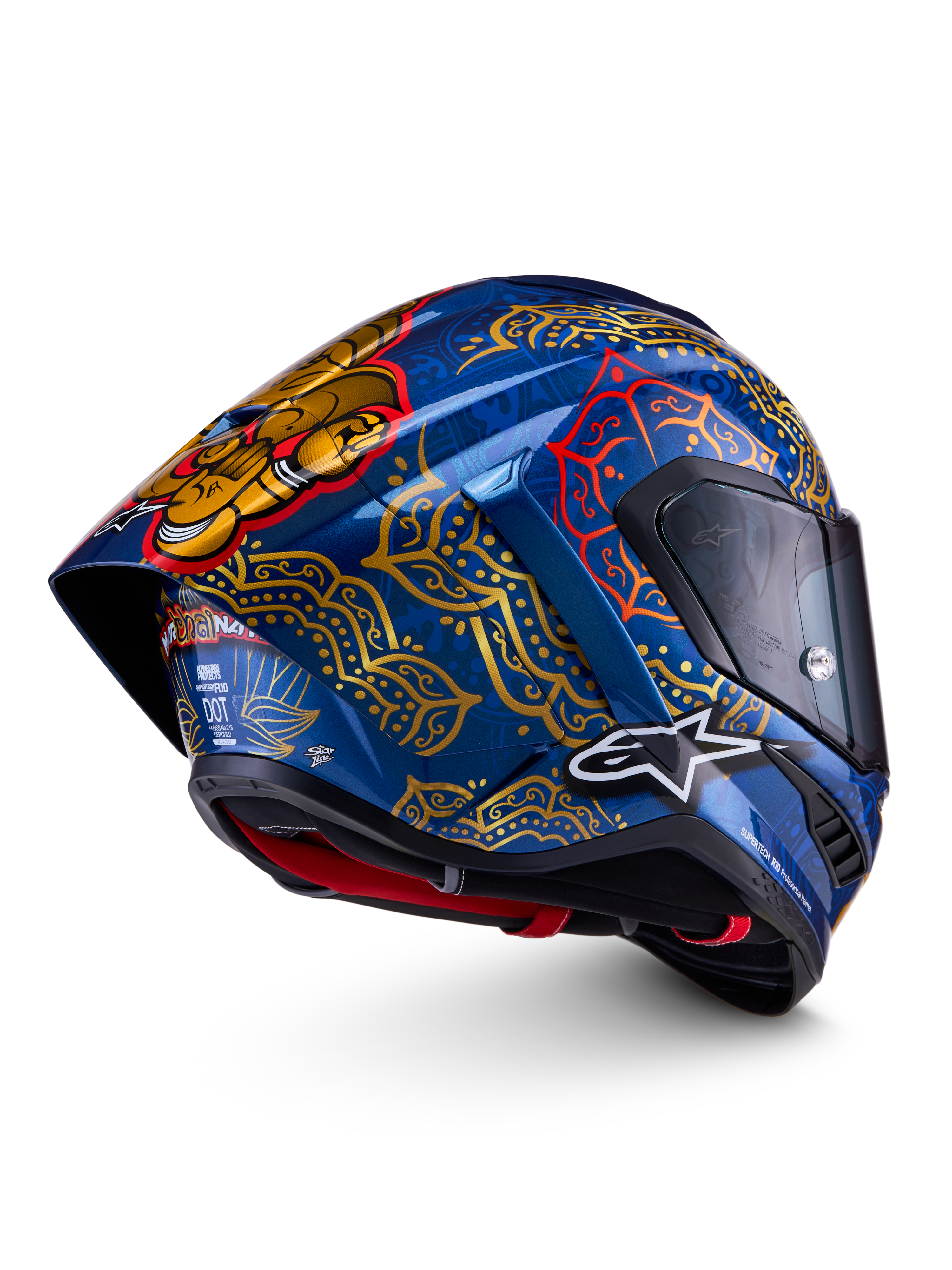 Alpinestars Supertech R10 Martinator Thai, wyścigowy kask motocyklowy, niebieski i złoty, skorupa z włókna węglowego, certyfikaty FIM, ECE i DOT, wzory mandali oraz aerodynamiczny tylny spoiler.