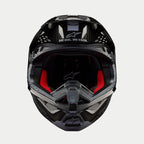 Kask Alpinestars Supertech M10 Solid, kask motocrossowy, czarny błyszczący karbon, widok z przodu ukazujący czerwoną wyściółkę wewnętrzną, skorupę z włókna węglowego oraz hasło „ONE GOAL. ONE VISION.” w obszarze daszka