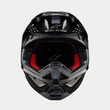 Kask Alpinestars Supertech M10 Solid, kask motocrossowy, czarny błyszczący karbon, widok z przodu ukazujący czerwoną wyściółkę wewnętrzną, skorupę z włókna węglowego oraz hasło „ONE GOAL. ONE VISION.” w obszarze daszka