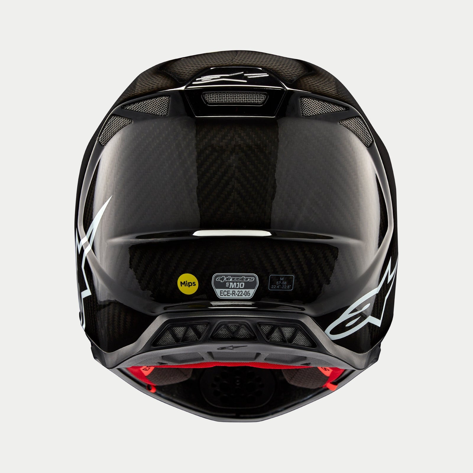 Kask Alpinestars Supertech M10 Solid, czarny połyskujący karbon, widok z tyłu prezentujący splot włókna węglowego, białe logo Alpinestars, naklejki certyfikacyjne MIPS i ECE, aerodynamiczny kształt z otworami wentylacyjnymi