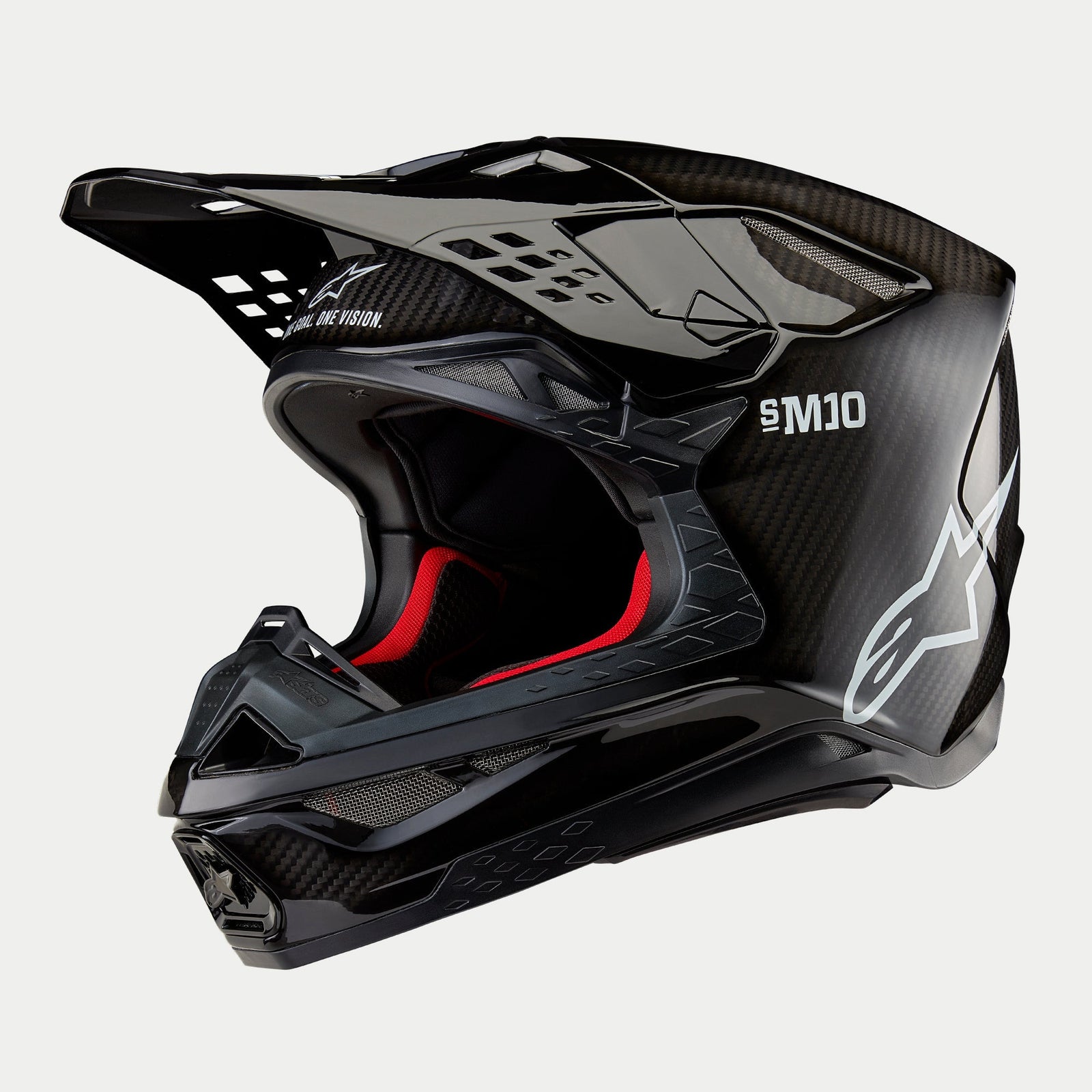 Kask Alpinestars Supertech M10 Solid, kask motocrossowy, czarny błyszczący karbon z widocznym splotem włókien, białe logo Alpinestars i oznaczenie SM10, czerwona wyściółka, aerodynamiczny design z licznymi otworami wentylacyjnymi