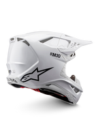 Alpinestars Supertech M10 Solid ECE 22.06, biały błyszczący kask motocrossowy z czarną grafiką, czerwonymi akcentami, otworami wentylacyjnymi i daszkiem