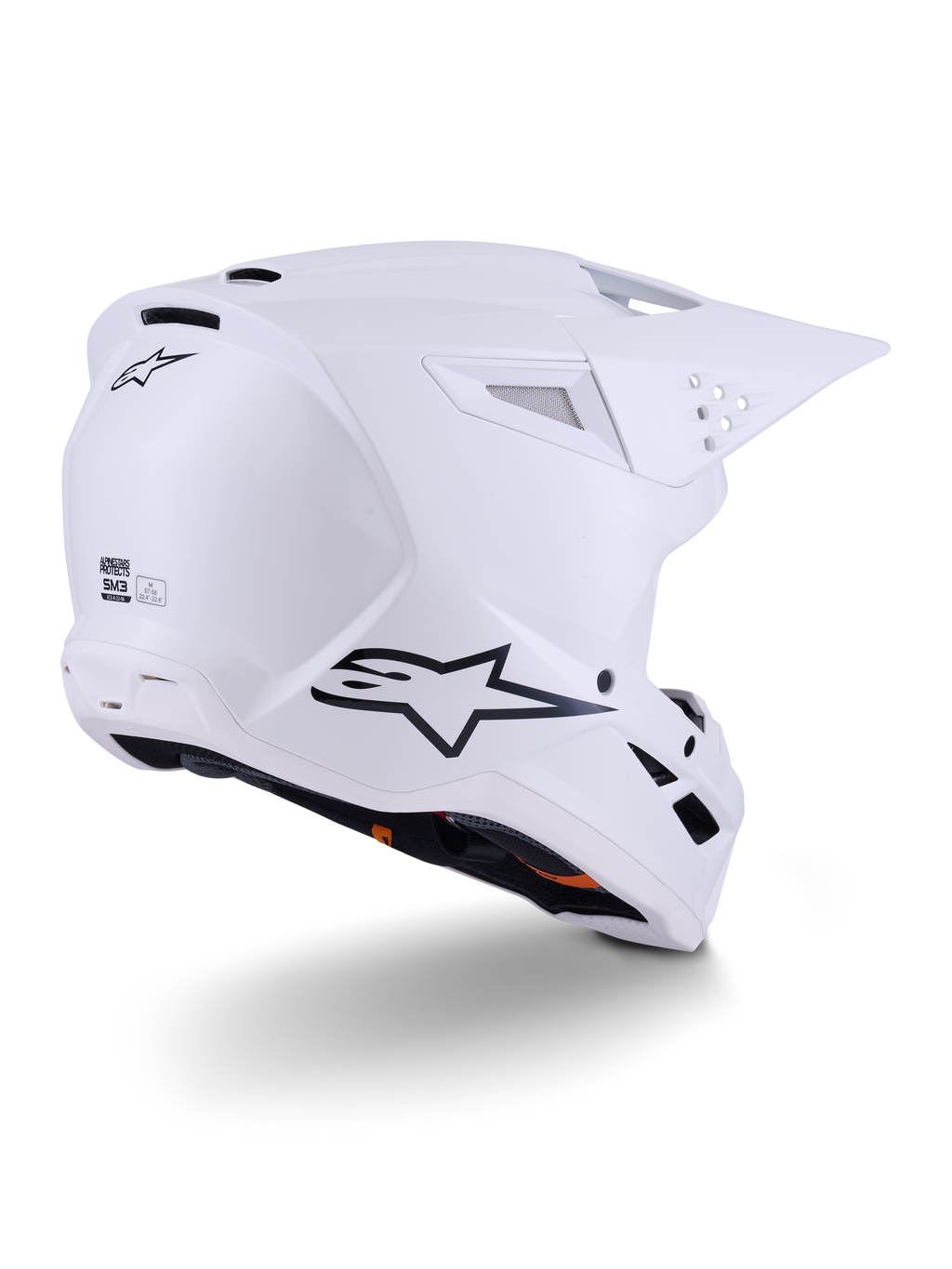 Kask Alpinestars S-M3 Solid, kask motocrossowy, biały z połyskiem, widok z tyłu pod kątem trzech czwartych pokazujący czarne logo Alpinestars, otwory wentylacyjne i aerodynamiczną konstrukcję skorupy do jazdy terenowej.
