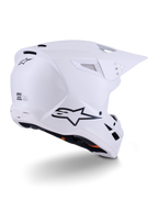 Kask Alpinestars S-M3 Solid, kask motocrossowy, biały z połyskiem, widok z tyłu pod kątem trzech czwartych pokazujący czarne logo Alpinestars, otwory wentylacyjne i aerodynamiczną konstrukcję skorupy do jazdy terenowej.