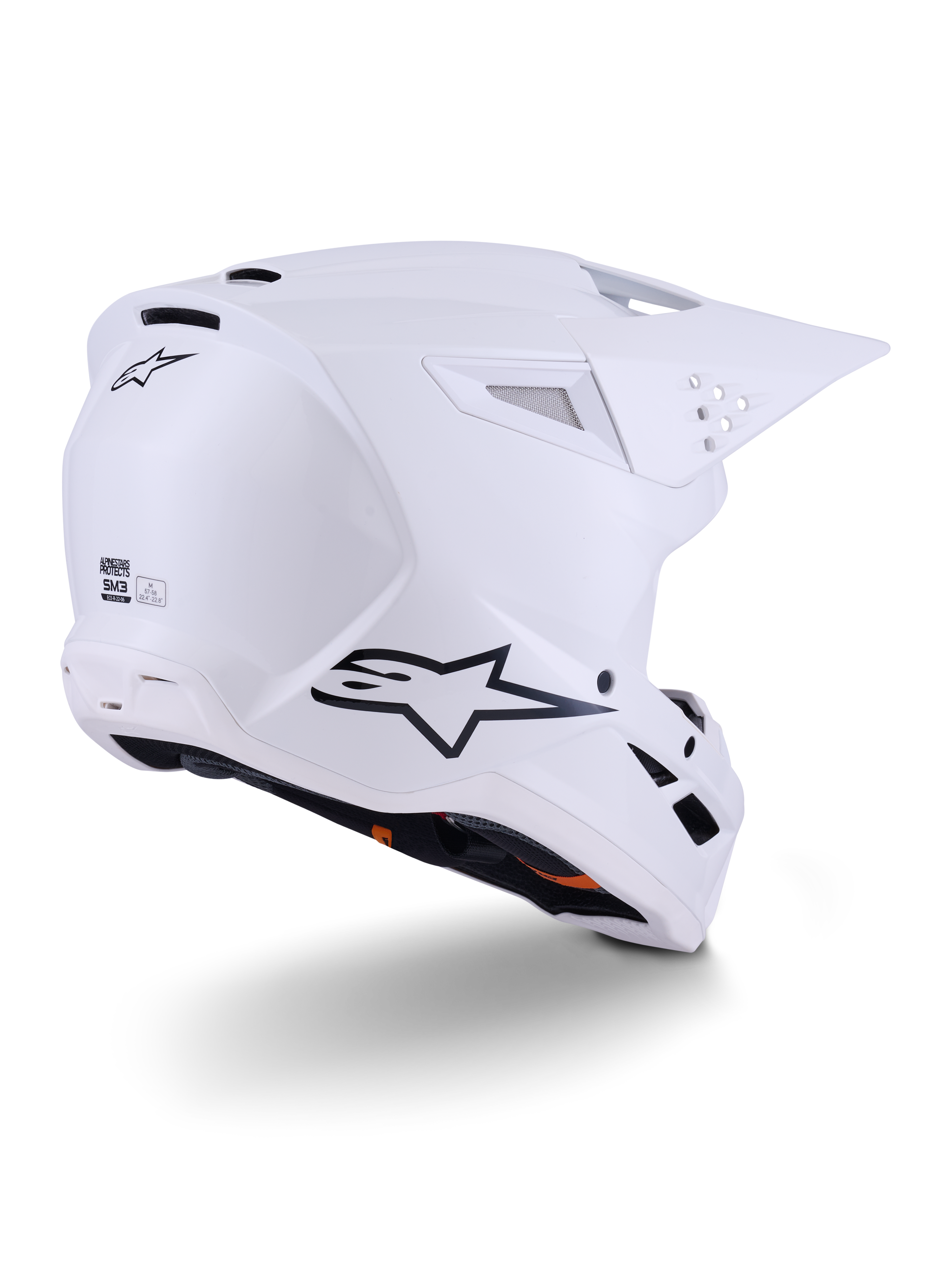 Kask Alpinestars S-M3 Solid, kask motocrossowy, biały z połyskiem, widok z tyłu pod kątem trzech czwartych pokazujący czarne logo Alpinestars, otwory wentylacyjne i aerodynamiczną konstrukcję skorupy do jazdy terenowej.