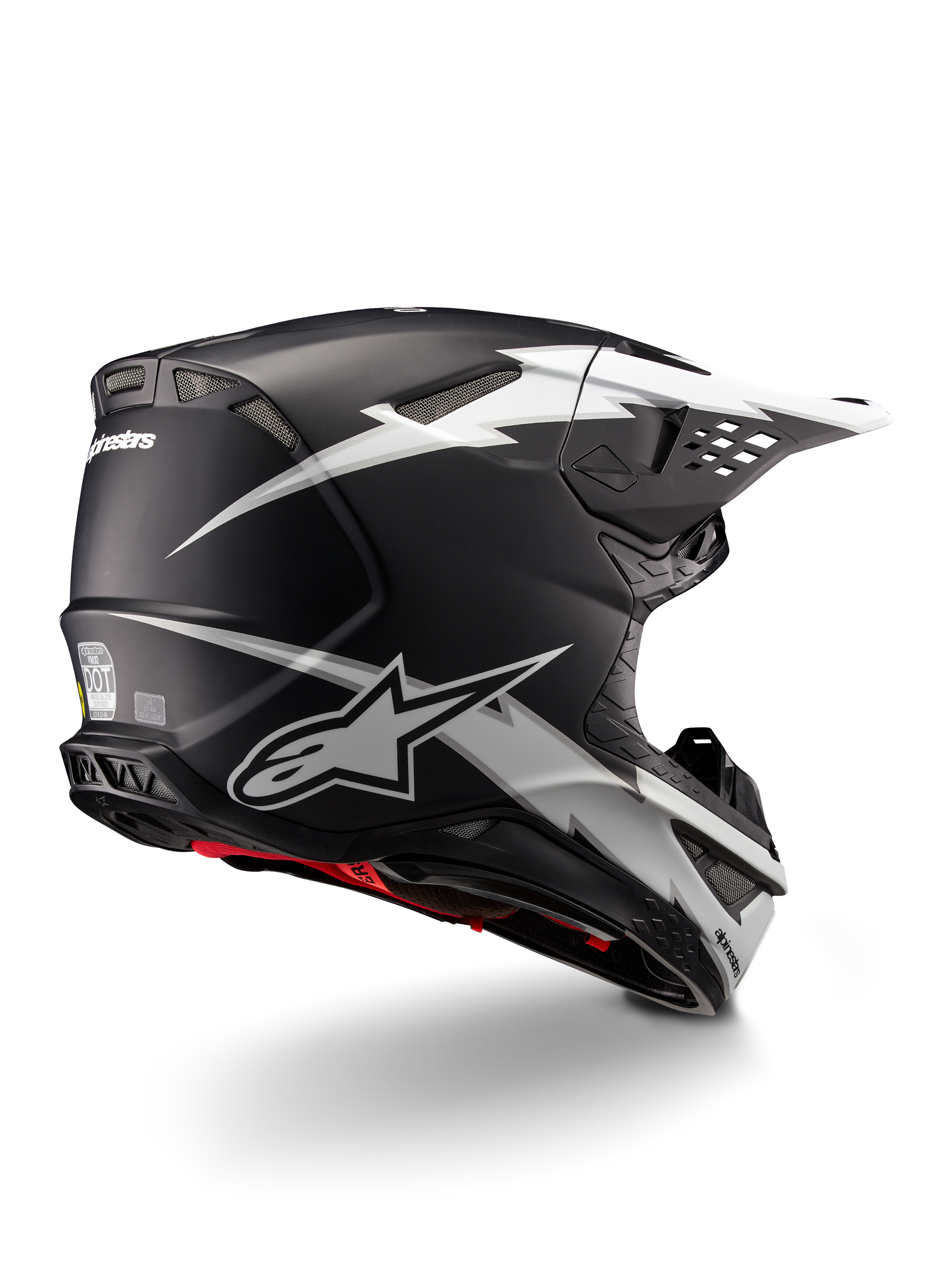 Kask Alpinestars Supertech M10 Ampress, kask motocrossowy, czarno-biały mat, z wyrazistą grafiką białych błyskawic na czarnej matowej skorupie, widok z tyłu pod kątem trzech czwartych pokazujący branding Alpinestars i otwory wentylacyjne