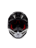 Kask Alpinestars Supertech M10 Ampress, kask motocrossowy, czarno-biały matowy, widok z przodu z czerwoną wyściółką wewnętrzną, aerodynamiczna skorupa z otworami wentylacyjnymi i logo Alpinestars