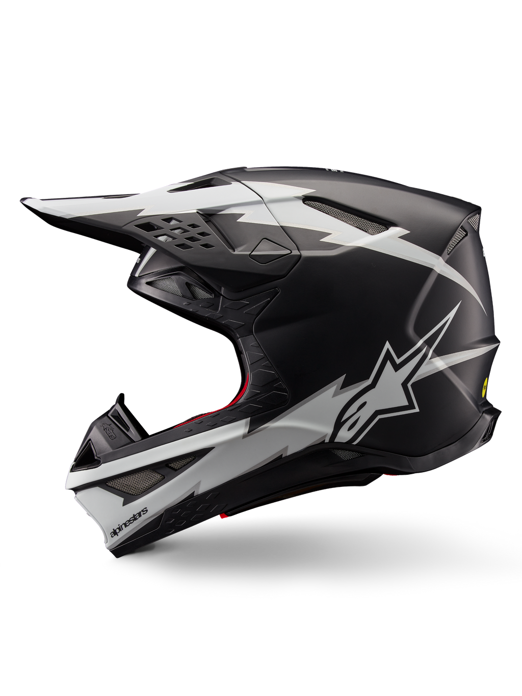Alpinestars Supertech M10 Ampress Helmet, kask motocrossowy, czarno-biały matowy, widok z boku z wyrazistymi białymi grafikami w stylu błyskawic, aerodynamiczna skorupa z widocznymi otworami wentylacyjnymi i daszkiem, zaawansowana ochrona off-road