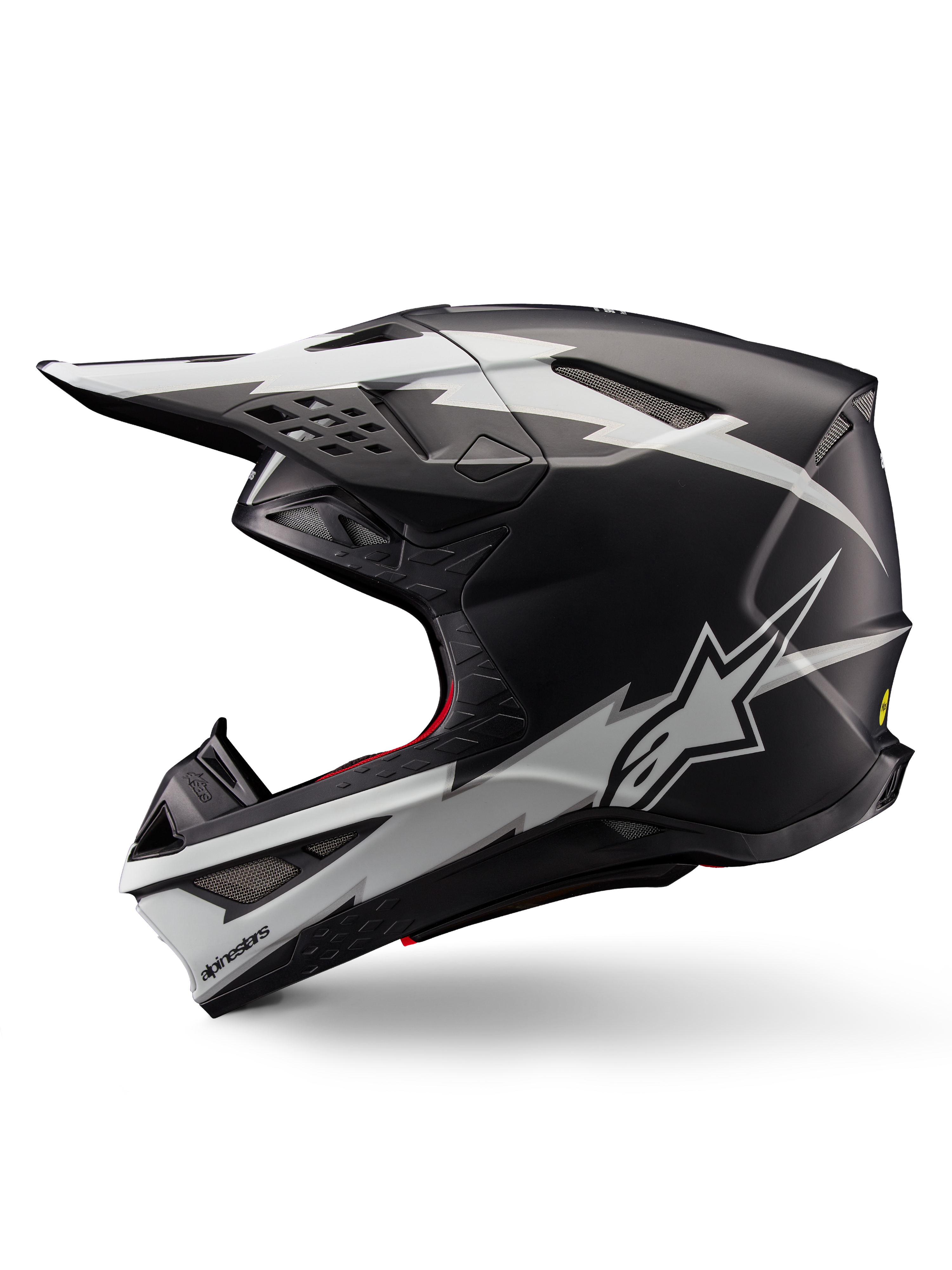 Alpinestars Supertech M10 Ampress Helmet, kask motocrossowy, czarno-biały matowy, widok z boku z wyrazistymi białymi grafikami w stylu błyskawic, aerodynamiczna skorupa z widocznymi otworami wentylacyjnymi i daszkiem, zaawansowana ochrona off-road
