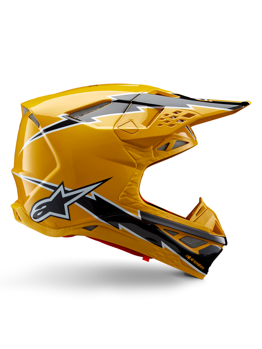 Kask Alpinestars Supertech M10 Ampress, kask motocrossowy, żółto-czarny błyszczący, profil boczny prezentujący wyraźne czarno-białe grafiki błyskawic, logo gwiazdy Alpinestars, aerodynamiczny design ze zintegrowanymi otworami wentylacyjnymi i regulowanym daszkiem.