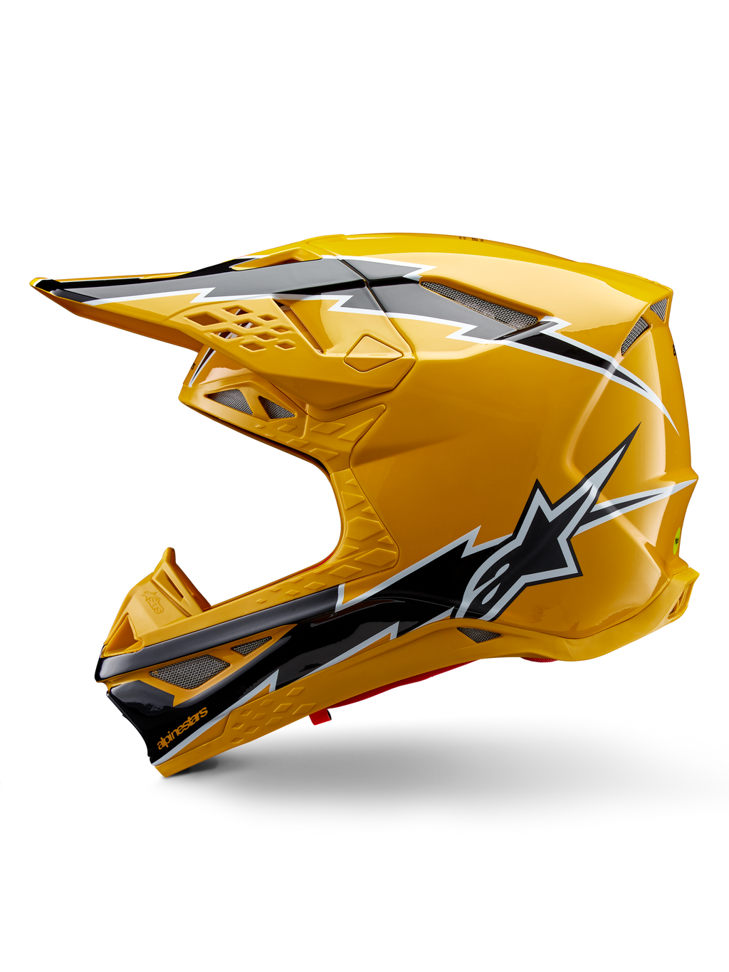 Kask Alpinestars Supertech M10 Ampress, kask motocrossowy, błyszczący żółty z czarno-białą grafiką, widok z boku z kanciastymi wzorami, logo gwiazdy Alpinestars, liczne otwory wentylacyjne ze srebrną siatką, profesjonalny sprzęt do wyścigów terenowych