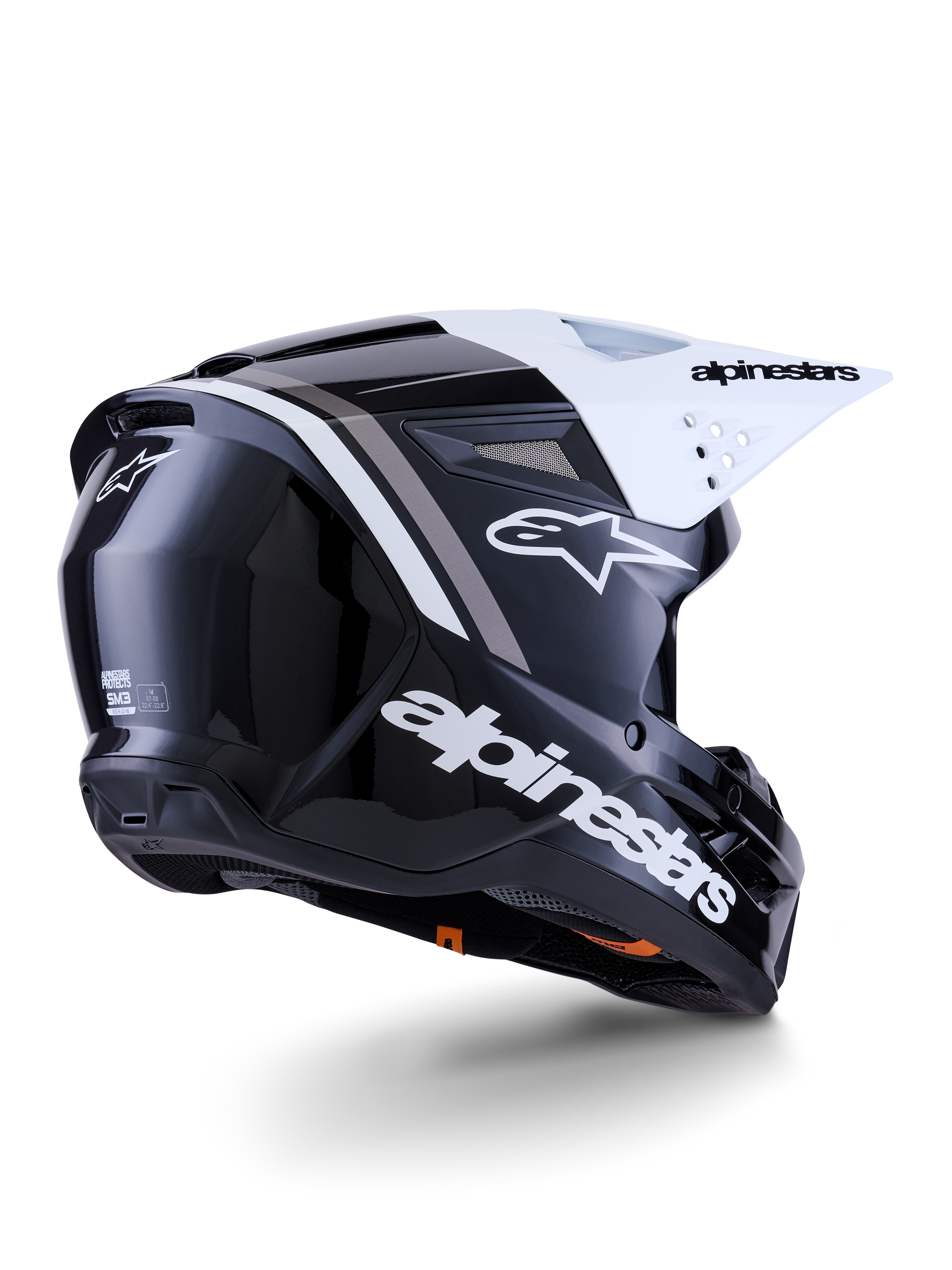 Kask Alpinestars S-M3 Radium, kask motocrossowy, czarno-biało-szary z połyskiem, widok z tyłu i z boku z białym daszkiem, z wyraźnym logo Alpinestars z boku i z tyłu, smukła aerodynamiczna skorupa z siatką wentylacyjną, zaprojektowany do jazdy off-road, motocross i enduro