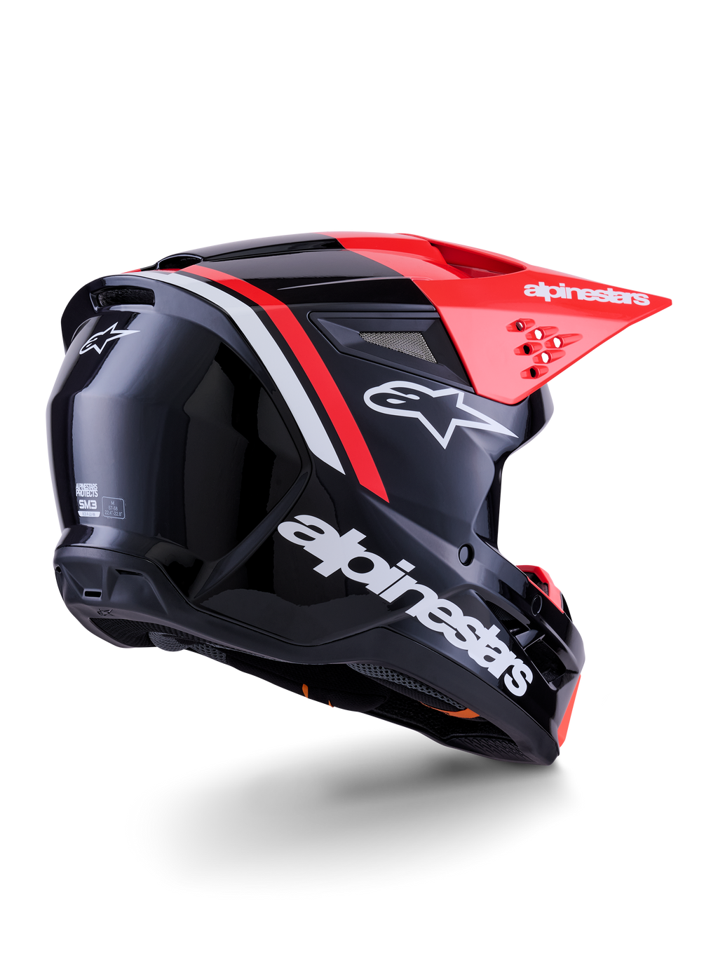 Kask Alpinestars S-M3 Radium, kask motocrossowy, czarny, czerwony fluo i biały z połyskiem, widok z tyłu pod kątem trzech czwartych ukazujący smukły aerodynamiczny design, białe logotypy i jaskrawoczerwony daszek, wysokiej jakości kask ochronny off-road
