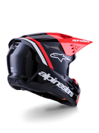 Kask Alpinestars S-M3 Radium, kask motocrossowy, czarny, czerwony fluo i biały z połyskiem, widok z tyłu pod kątem trzech czwartych ukazujący smukły aerodynamiczny design, białe logotypy i jaskrawoczerwony daszek, wysokiej jakości kask ochronny off-road