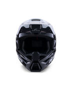 Kask Alpinestars S-M3 Radium, kask motocrossowy, czarno-biało-szary z połyskiem, widok z przodu, agresywny design skorupy z białym daszkiem, czarną osłoną szczęki i otworami wentylacyjnymi z siateczką.