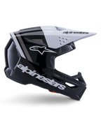 Kask Alpinestars S-M3 Radium, kask motocrossowy off-road, czarno-biało-szary z połyskiem, kanciasty aerodynamiczny design z otworami wentylacyjnymi, widok z profilu, błyszczące wykończenie z szarymi pasami, biały daszek z logo Alpinestars
