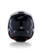 Kask Alpinestars S-M3 Radium ECE 22.06, kask motocrossowy, czarno-biało-szary z połyskiem, widok z tyłu prezentujący błyszczące czarne wykończenie, logo gwiazdy Alpinestars, otwory wylotowe wentylacji oraz etykietę certyfikacji ECE