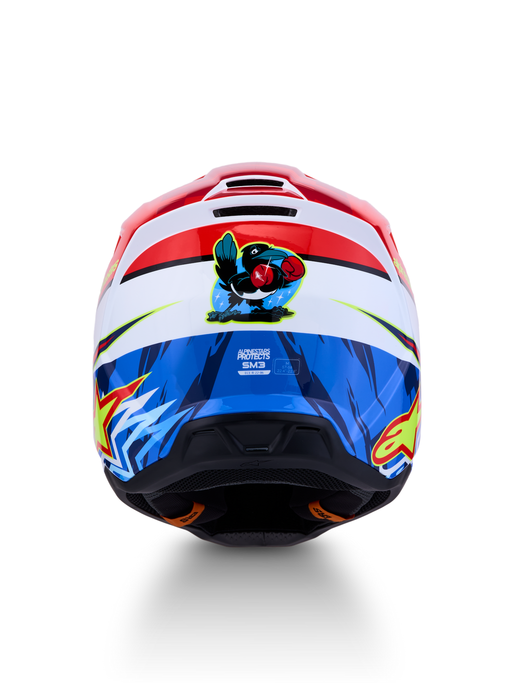 Kask Alpinestars SM3 Falcon ECE06, czerwono-niebieski kask motocrossowy z grafiką rysunkowego sokoła z tyłu.