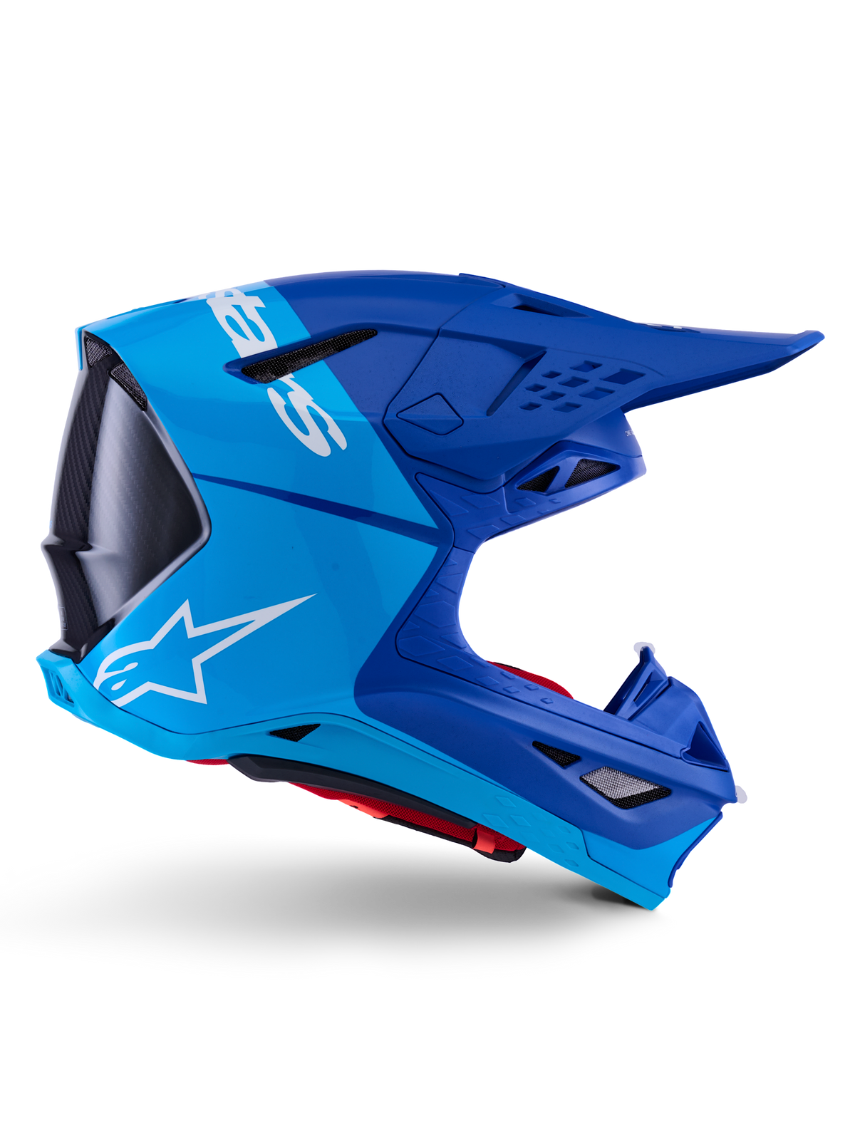Kask Alpinestars Supertech M10 Flood, kask motocrossowy, metaliczny i średni niebieski z czarnymi karbonowymi akcentami, widok z boku, białe logo, aerodynamiczny design z otworami wentylacyjnymi, detale o strukturze włókna węglowego, profesjonalna ochrona do wyścigów off-road