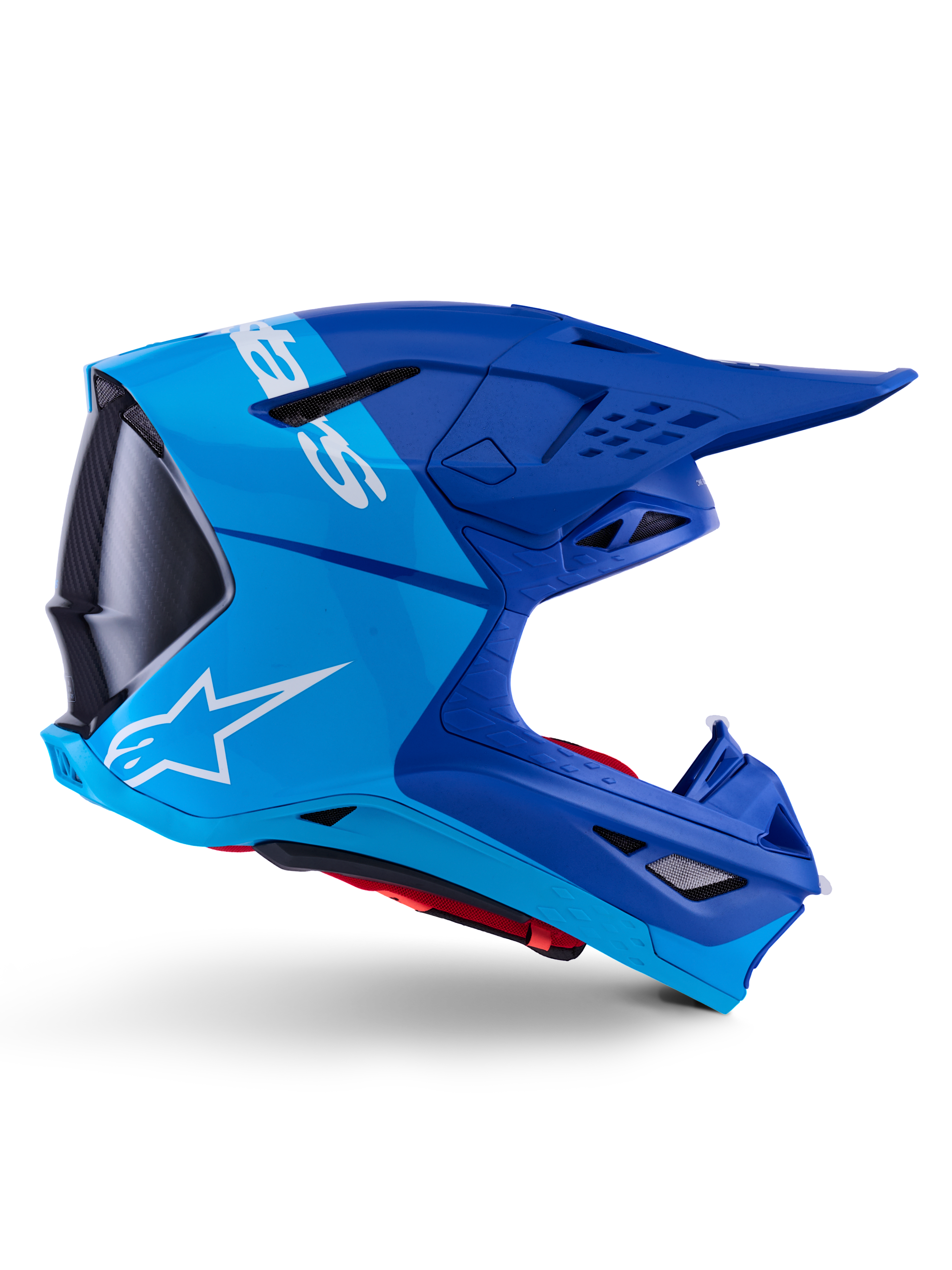 Kask Alpinestars Supertech M10 Flood, kask motocrossowy, metaliczny i średni niebieski z czarnymi karbonowymi akcentami, widok z boku, białe logo, aerodynamiczny design z otworami wentylacyjnymi, detale o strukturze włókna węglowego, profesjonalna ochrona do wyścigów off-road