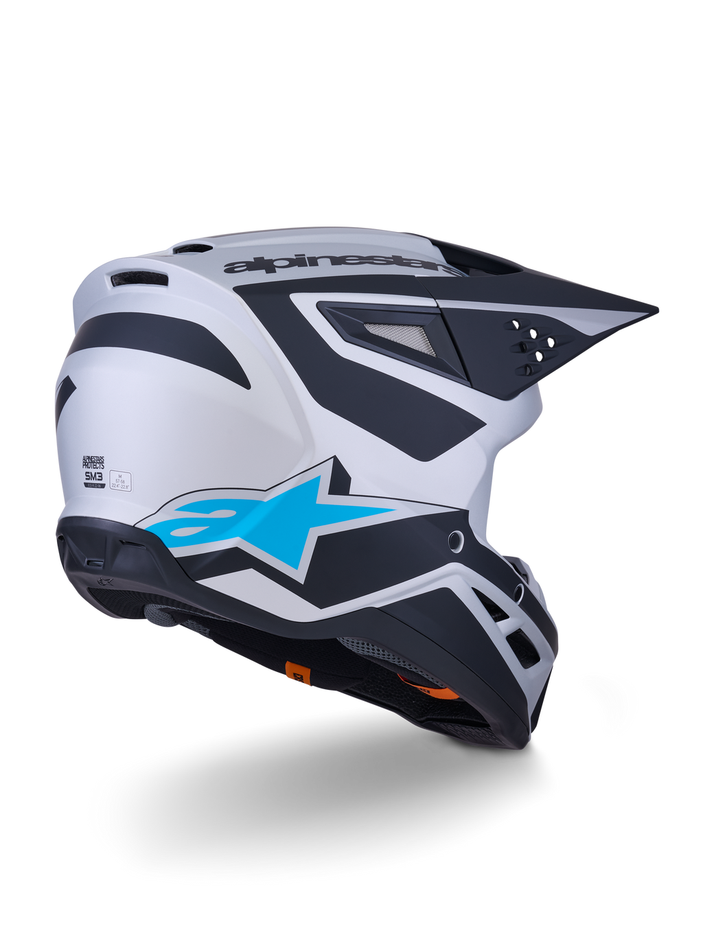 Alpinestars S-M3 Heat Helmet ECE 22.06, kask motocrossowy, srebrno-niebieski i czarny mat, widok z tyłu z dużym niebieskim logo gwiazdy i czarnymi kanciastymi wzorami, aerodynamiczna skorupa z otworami wentylacyjnymi, wysokowydajna ochrona do wyścigów off-road