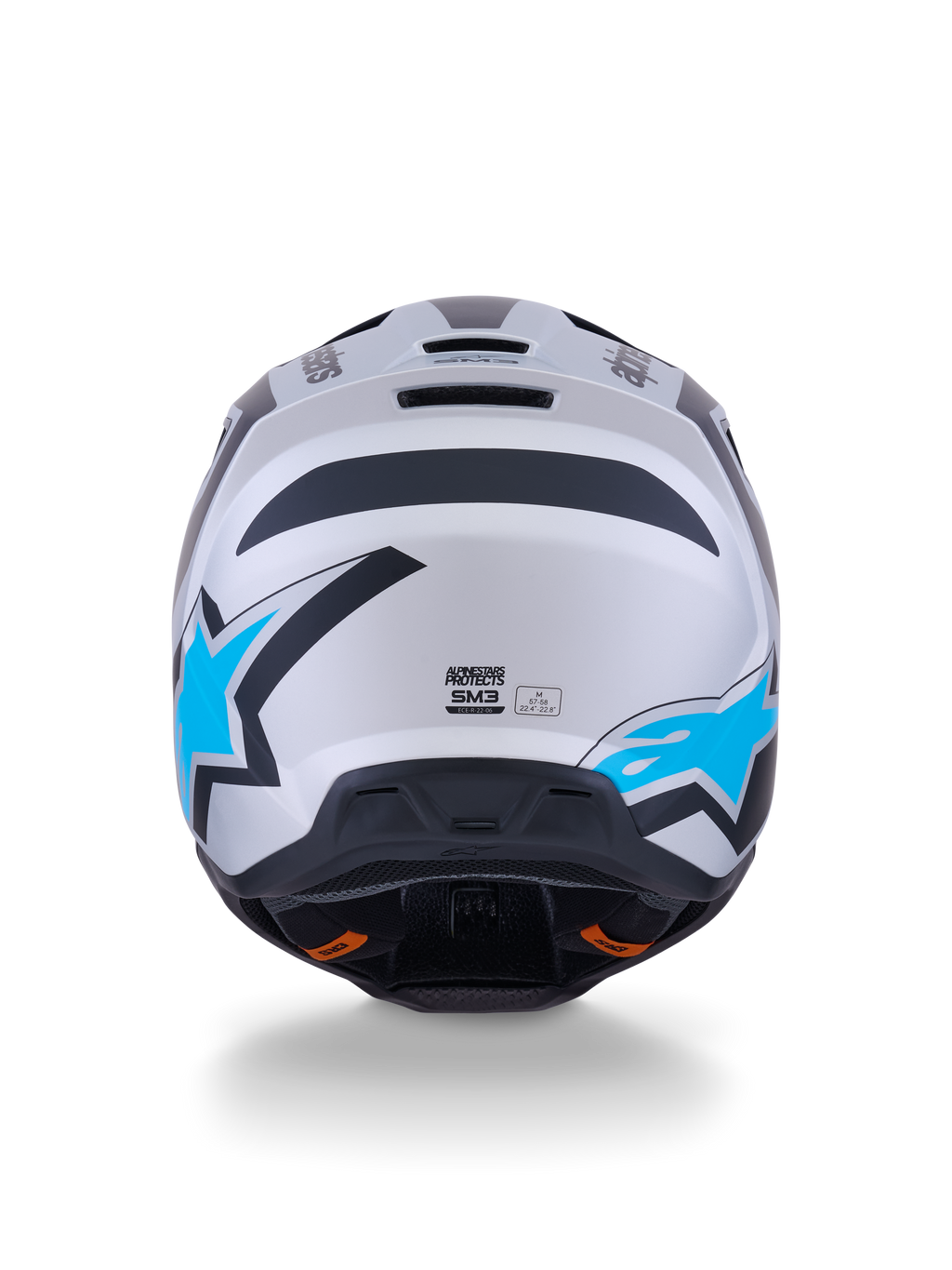 Kask Alpinestars S-M3 Heat, kask motocrossowy, srebrno-niebiesko-czarny mat, widok z tyłu ukazujący jasnoniebieskie logo z gwiazdą, matowe wykończenie i zintegrowane otwory wentylacyjne.