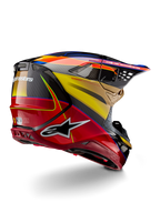 Alpinestars Supertech M10 Era, kask motocrossowy, złoto-żółty i czerwony Rio z połyskiem, widok z tyłu pod kątem trzech czwartych ukazujący skorupę z włókna węglowego, czerwone i żółte grafiki, niebieskie akcenty, aerodynamiczny profil, liczne otwory wentylacyjne i logo Astar