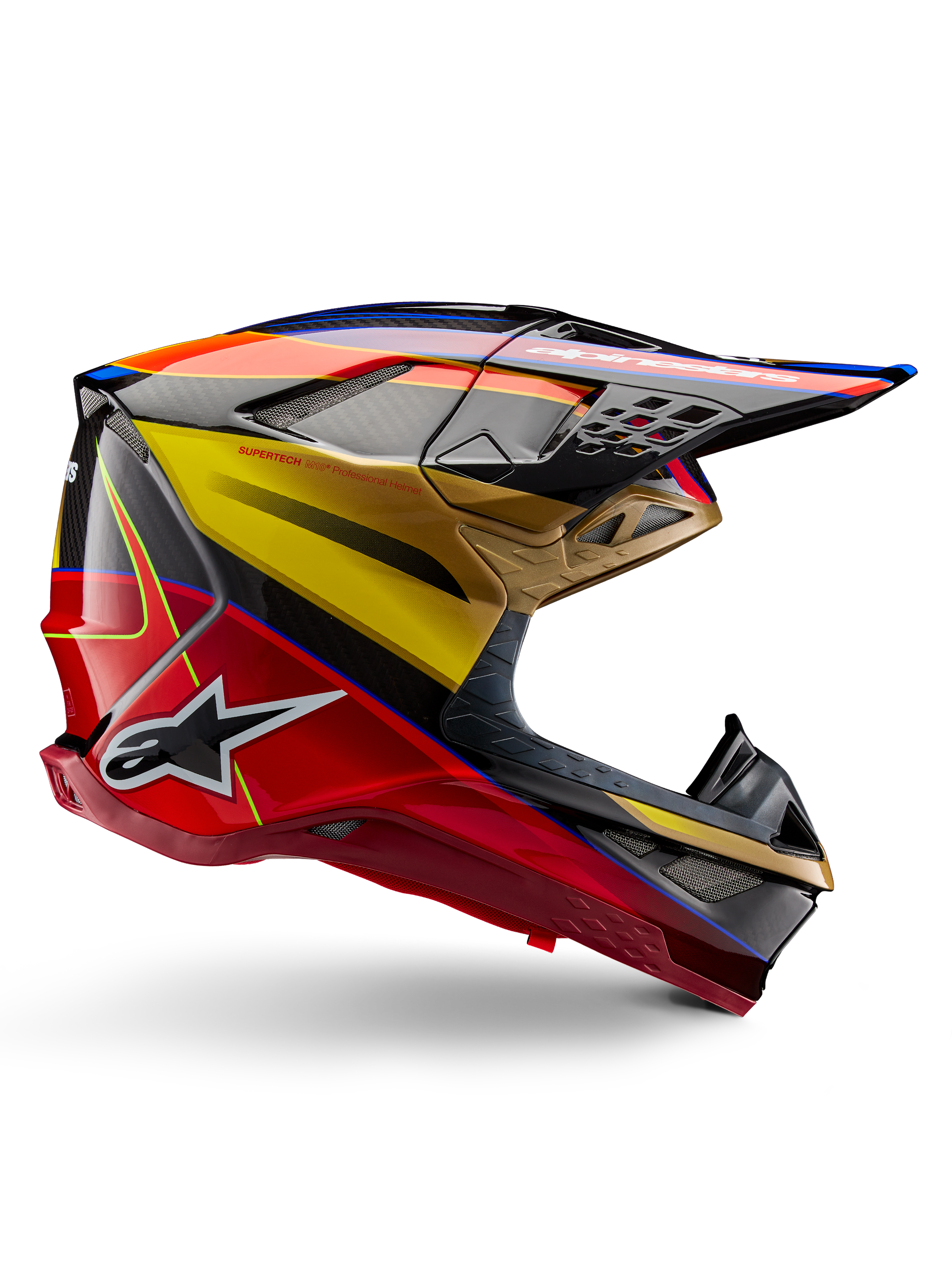 Kask Alpinestars Supertech M10 Era, kask motocrossowy, błyszczący kolor złoty, żółty i czerwony z niebieskimi i czarnymi akcentami, aerodynamiczny design ze zintegrowanym daszkiem, liczne otwory wentylacyjne zabezpieczone siatką i detale z włókna węglowego, certyfikat ECE 22.06