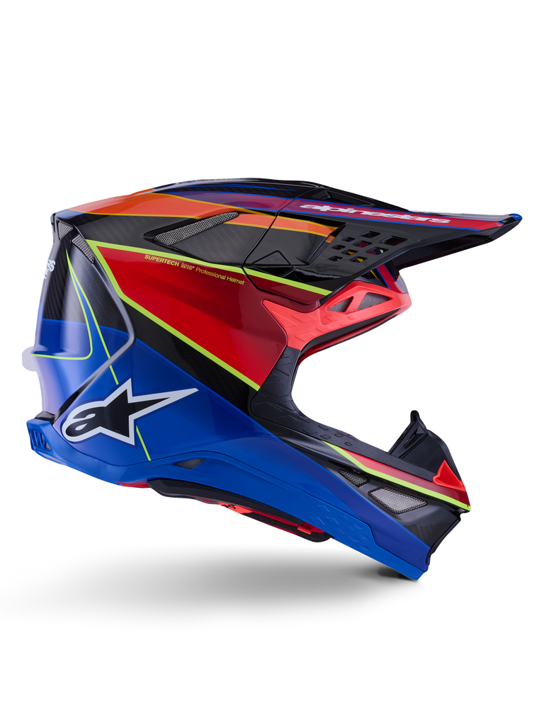 Kask Alpinestars Supertech M10 Era, kask motocrossowy, niebieski, czerwony i żółty fluo, błyszczący, widok z boku prezentujący wielokompozytową skorupę z włókna węglowego, białe logo Alpinestars, aerodynamiczny design z wieloma otworami wentylacyjnymi do wyścigów off-road