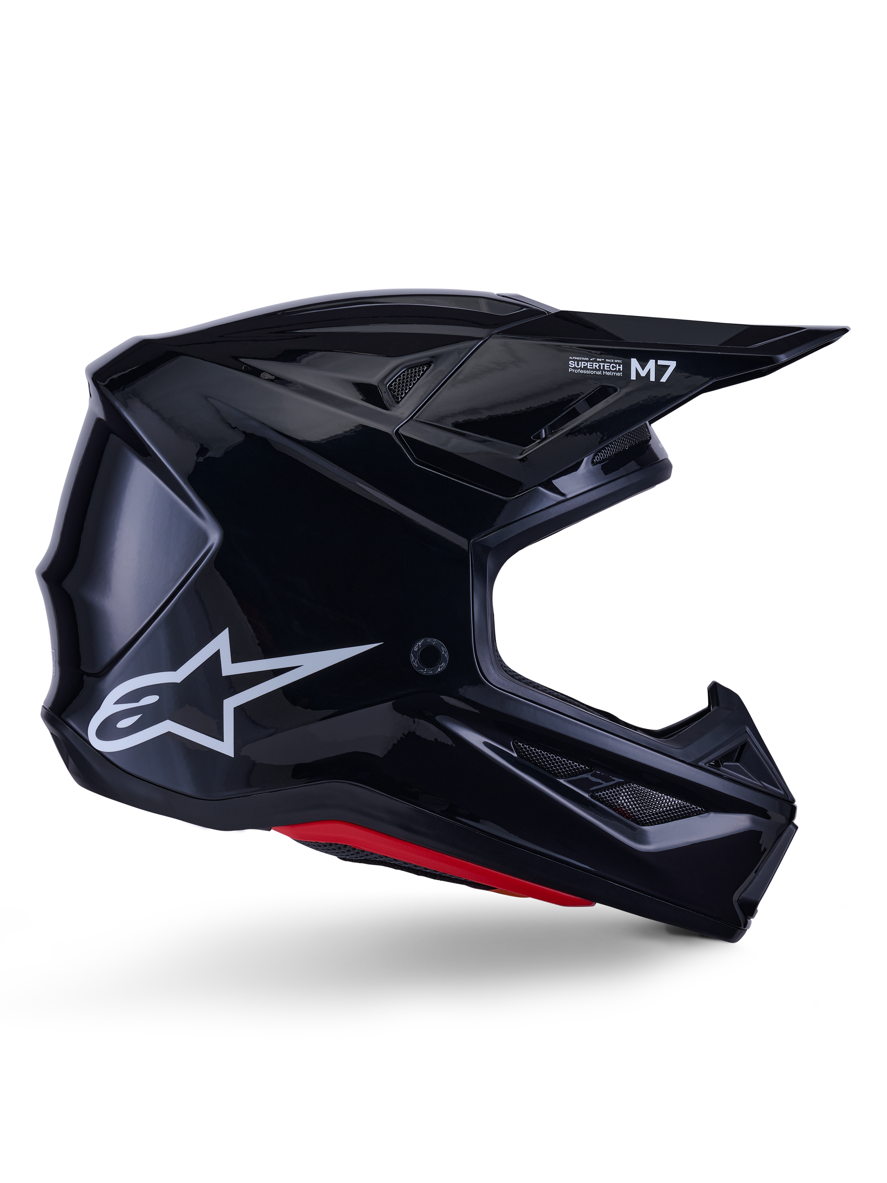 Kask Alpinestars S-M7 Solid, kask motocrossowy, czarny z połyskiem, białe logo gwiazdy i czerwone akcenty, profil boczny prezentujący aerodynamiczny design z kanciastymi otworami wentylacyjnymi i brandingiem Supertech M7 na daszku.