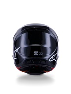 Alpinestars S-M7 Solid Helmet ECE 22.06, kask motocrossowy, czarny połysk, widok z tyłu z białymi logo gwiazdy, aerodynamiczna kompozytowa skorupa z wykończeniem na wysoki połysk, certyfikat bezpieczeństwa i oznaczenie rozmiaru na środku