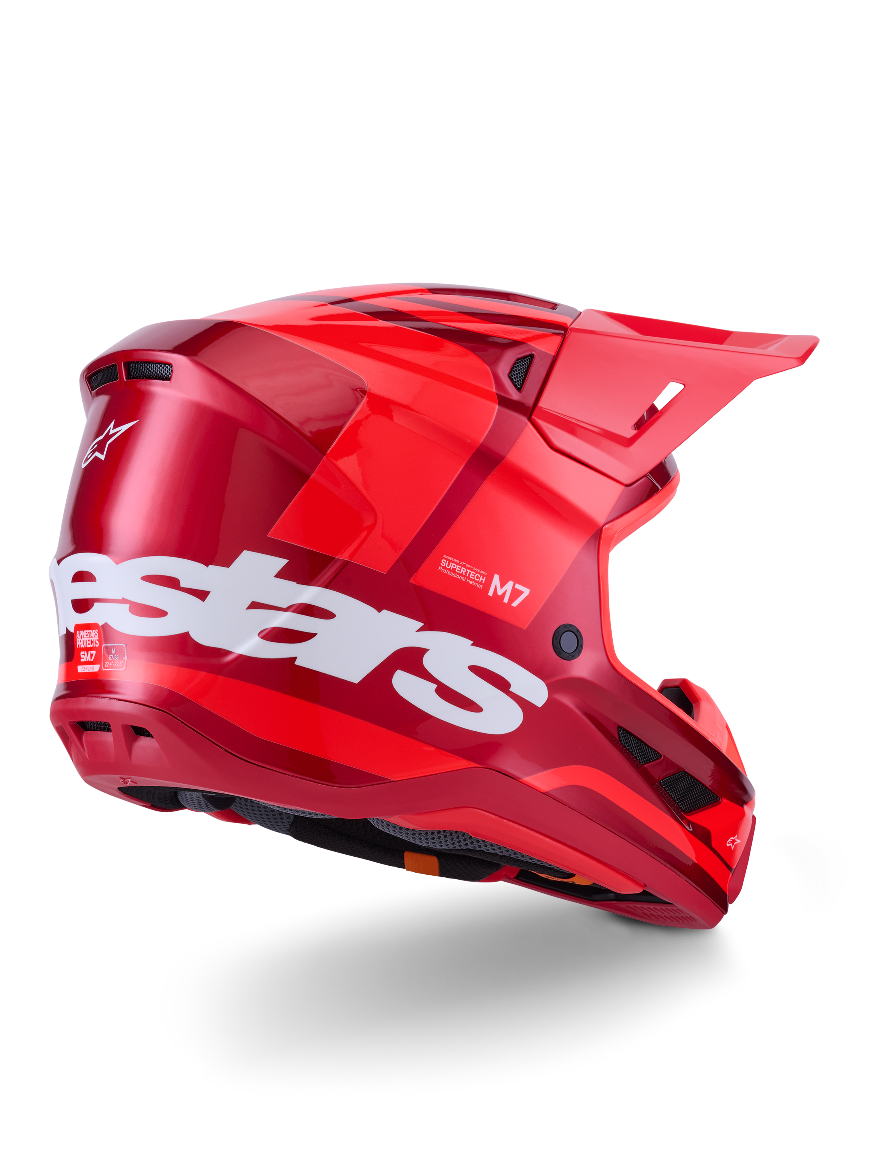 Kask Alpinestars S-M7 Core, kask motocrossowy, czerwony błyszczący z dużym białym logo Alpinestars z boku, posiadający aerodynamiczną skorupę, zintegrowane otwory wentylacyjne i daszek ochronny, widok 3/4 z tyłu