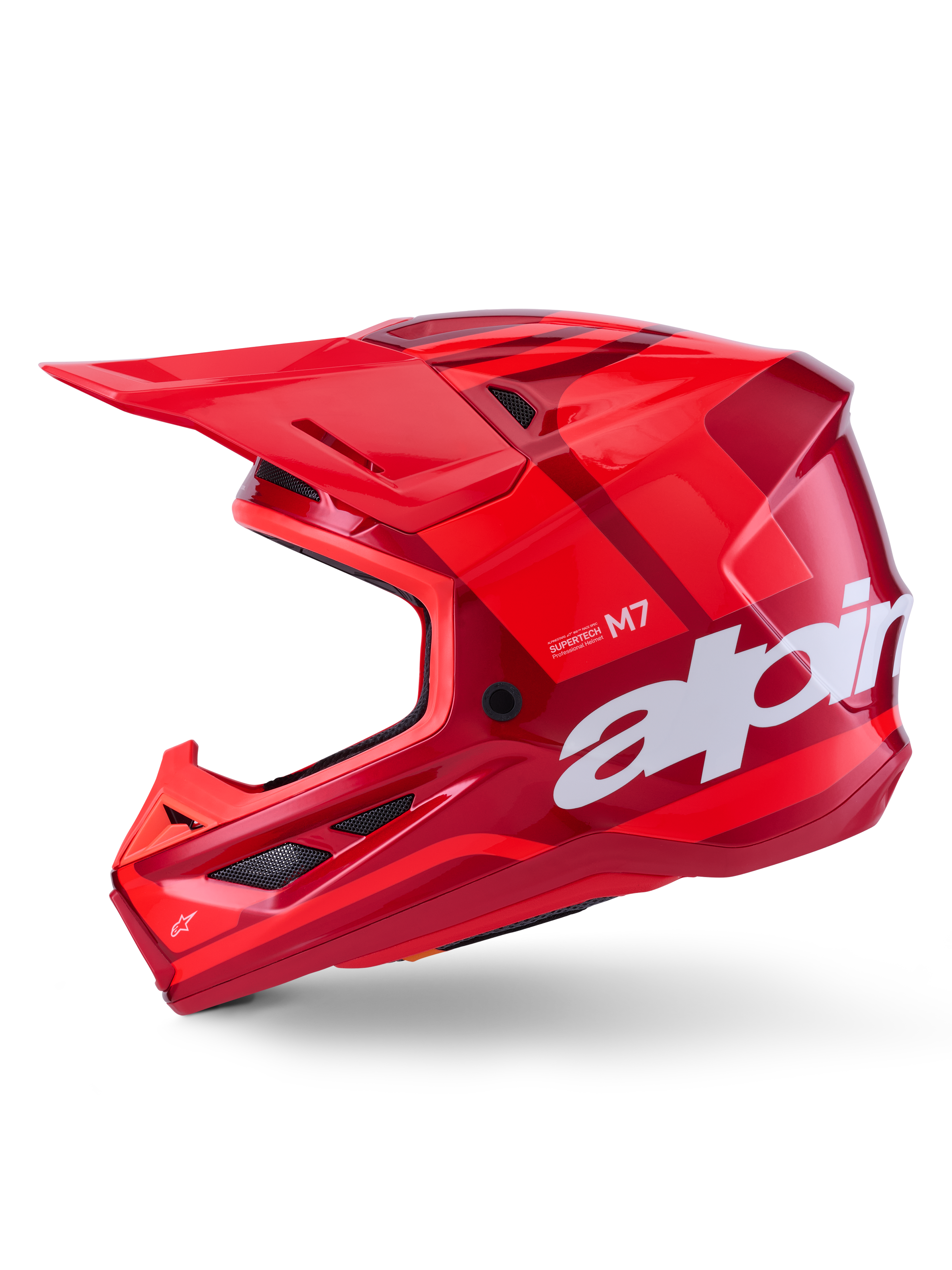 Kask Alpinestars S-M7 Core, czerwony błyszczący z geometrycznymi akcentami, kask motocrossowy, widok z profilu, aerodynamiczna skorupa z otworami wentylacyjnymi i białym logo, wysokiej klasy wyczynowy sprzęt off-road