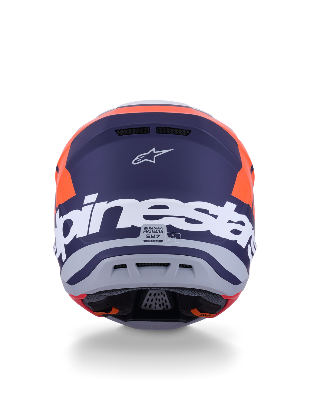 Kask Alpinestars S-M7 Core ECE 22.06, kask motocrossowy, pomarańczowy i niebieski matowy, widok z tyłu z dużym białym napisem Alpinestars i logo Astars, smukły aerodynamiczny design ze zintegrowanymi otworami wylotowymi, profesjonalna ochrona off-road