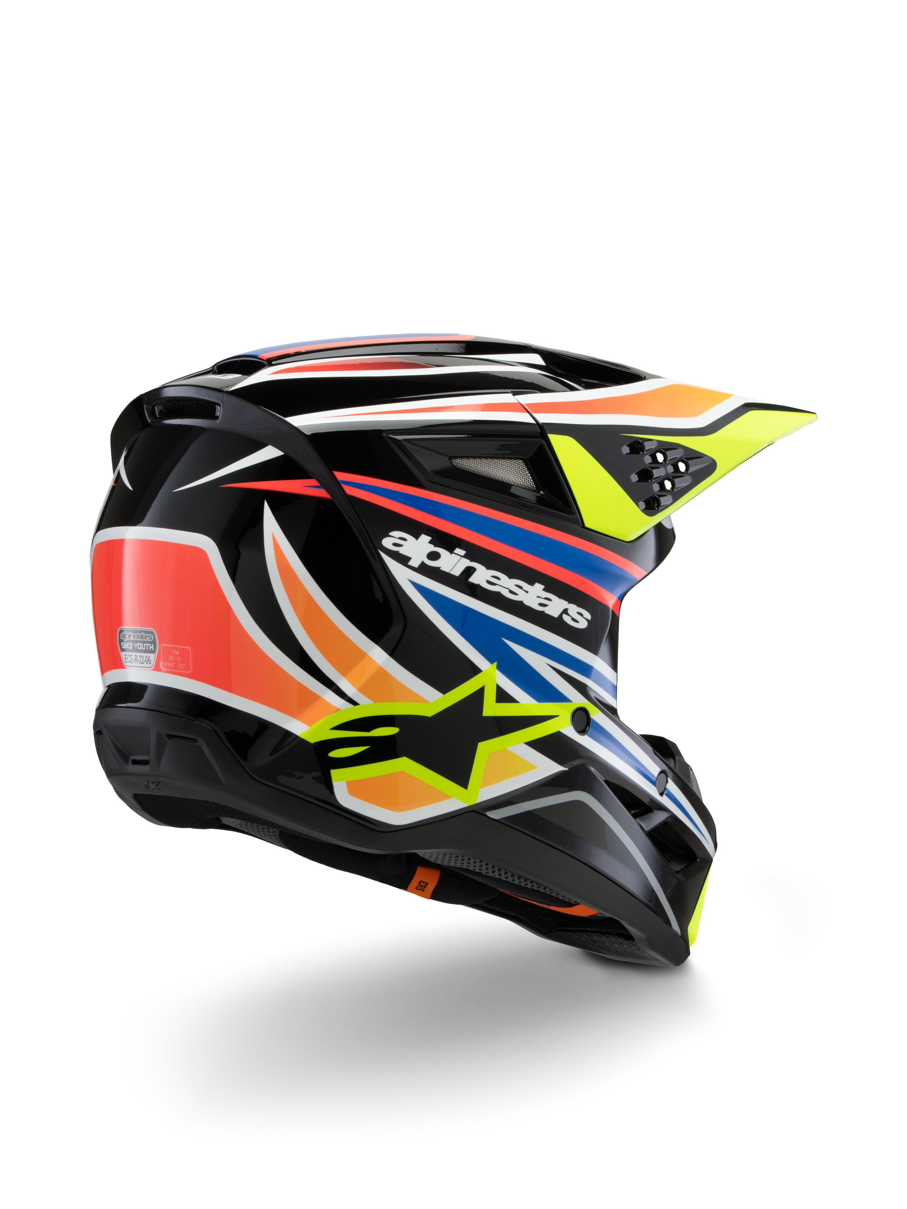 Kask Alpinestars S-M3 Youth Wurx, młodzieżowy kask motocrossowy, czarny z intensywnymi pomarańczowymi, czerwonymi, niebieskimi i jaskrawożółtymi akcentami, widok z tyłu pod kątem trzech czwartych ukazujący aerodynamiczną skorupę i otwory wentylacyjne, błyszczące wykończenie z wyraźnym brandingiem Alpinestars