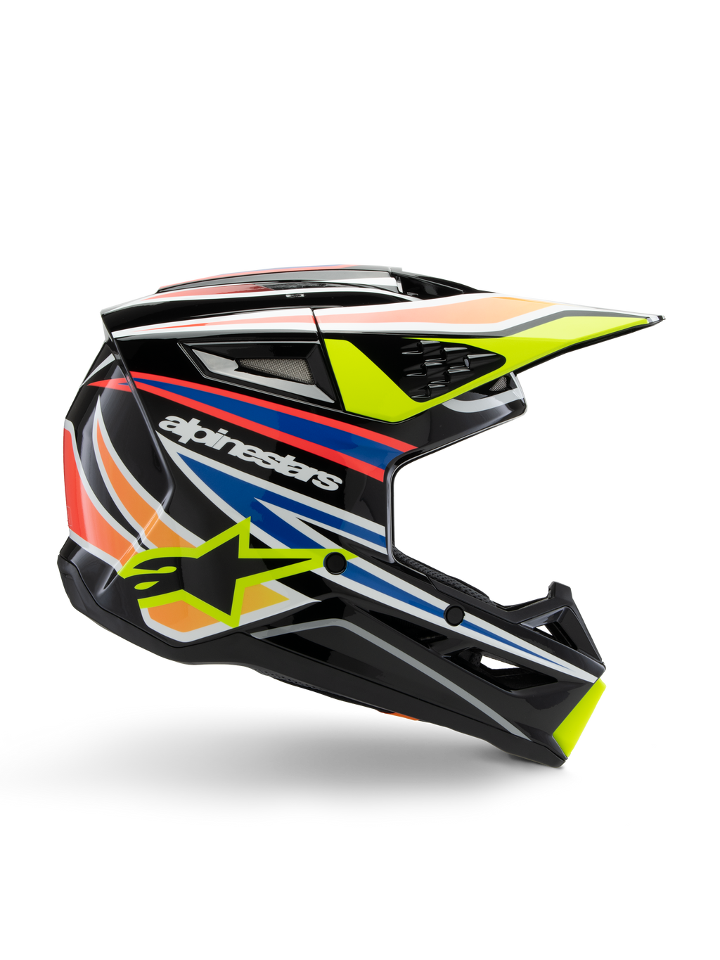 Kask Alpinestars S-M3 Youth Wurx, młodzieżowy kask motocrossowy, czarny z żółtymi, niebieskimi, czerwonymi i pomarańczowymi pasami, widok z boku z aerodynamicznym daszkiem i błyszczącym wykończeniem, białe logo Alpinestars i żółta grafika gwiazdy