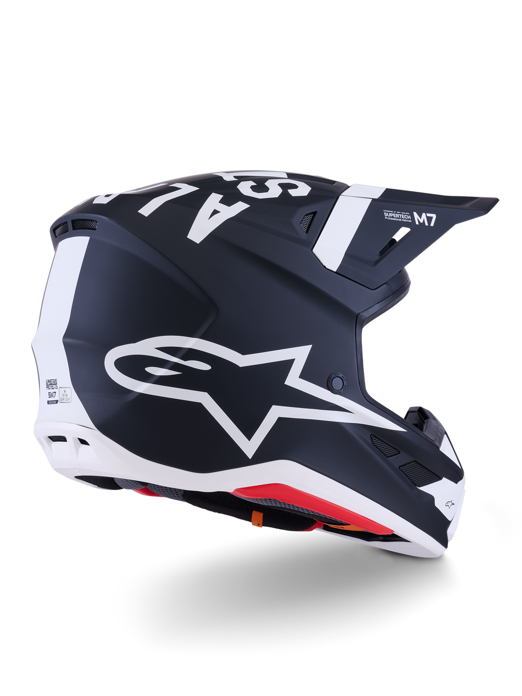 Kask Alpinestars S-M7 Dasher, kask motocrossowy, matowy czarno-biały, widok z tyłu pod kątem trzech czwartych z dużym białym logo A-star z boku, wyraźnym białym brandingiem na górze, aerodynamiczną konstrukcją skorupy z widocznymi otworami wentylacyjnymi i czerwoną wyściółką.