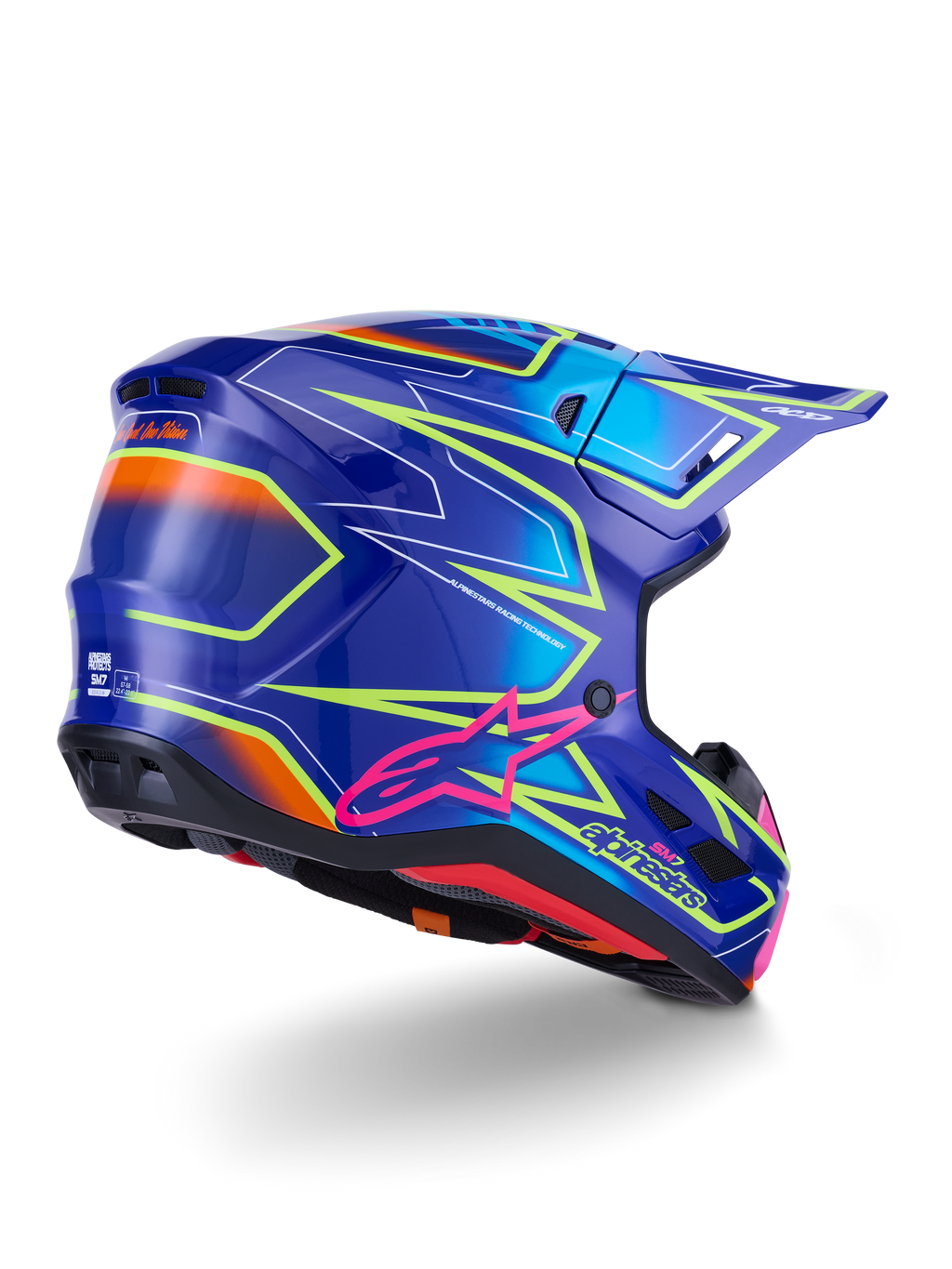 Kask Alpinestars S-M7 Cast, kask motocrossowy, błyszczący niebieski, różowy i żółty fluo, widok z tyłu pod kątem trzech czwartych ukazujący aerodynamiczną skorupę z wyrazistymi kanciastymi grafikami, różowe logo Astar i zintegrowane otwory wentylacyjne do wyścigów off-road