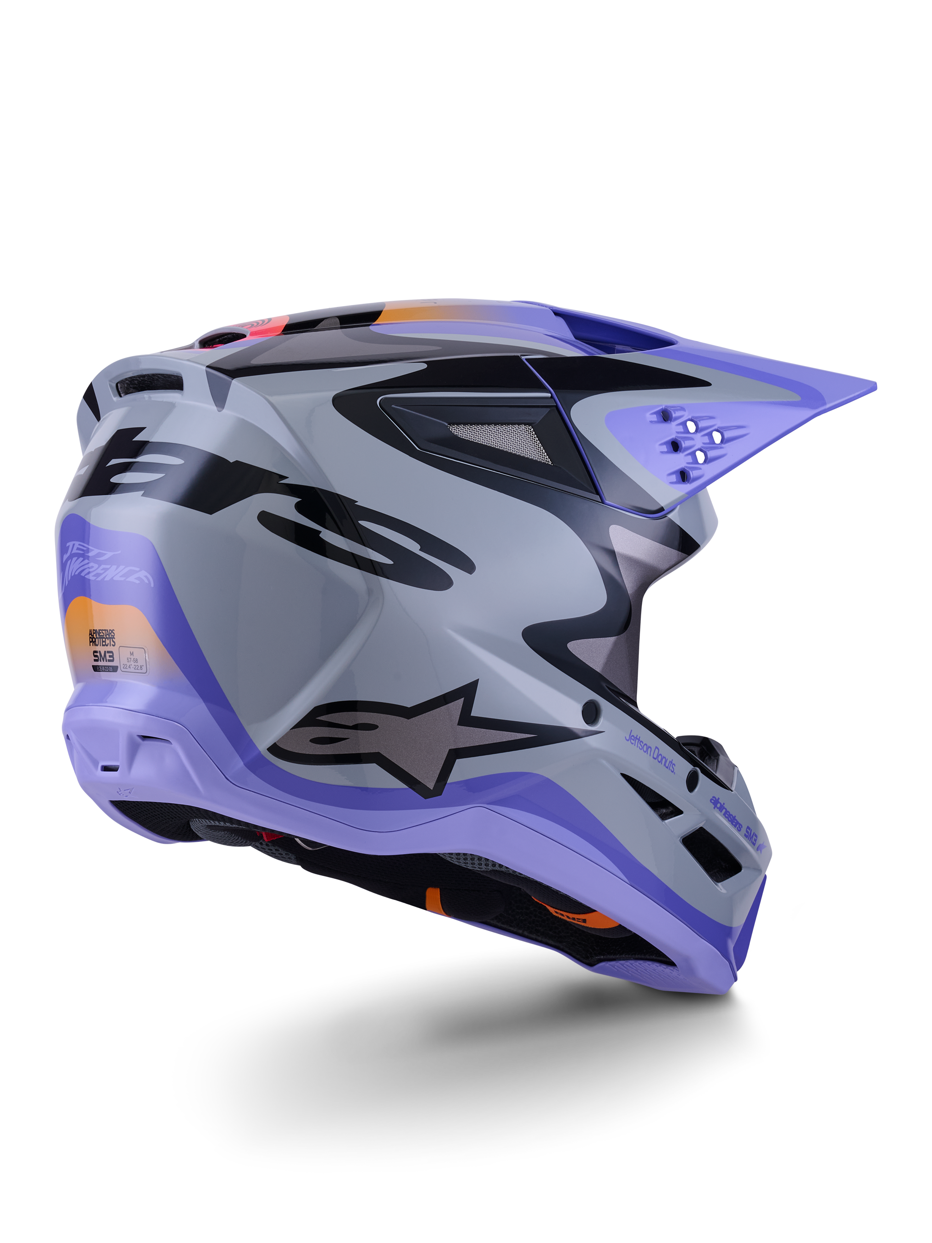 Alpinestars S-M3 Jettson Helmet ECE 22.06, kask motocrossowy, szary, fioletowy i czarny z połyskiem, widok z tyłu pod kątem trzech czwartych ukazujący aerodynamiczną termo-wtryskiwaną skorupę z otworami wentylacyjnymi i wyrazistym projektem graficznym
