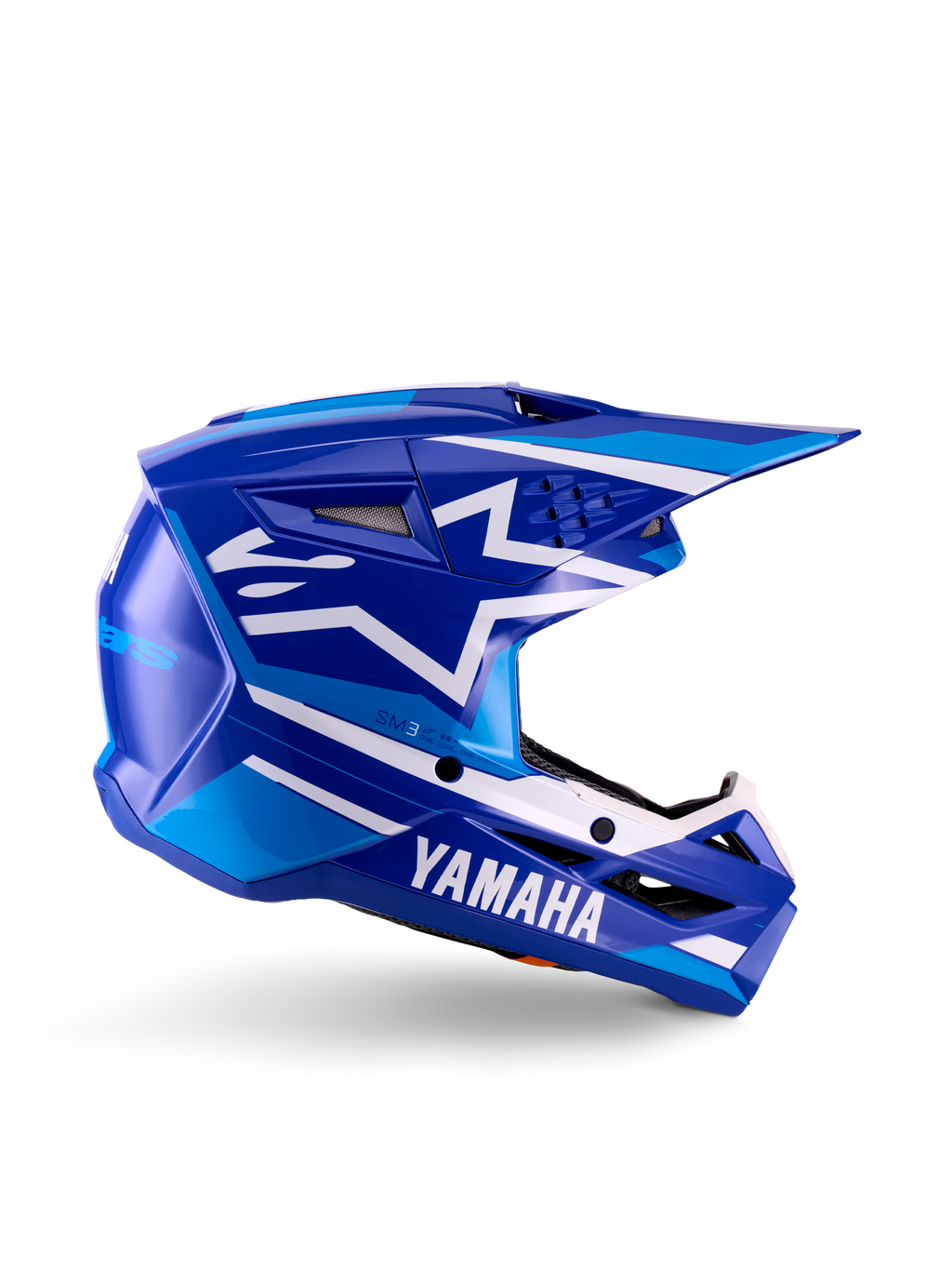 Młodzieżowy kask motocrossowy Yamaha S-M3, niebiesko-biały błyszczący, widok z boku z wyraźnym brandingiem Yamaha i logo gwiazdy Alpinestars, geometryczny wzór z jasnoniebieskimi akcentami, wentylowana skorupa z długim daszkiem, ochrona głowy off-road z certyfikatem ECE 22.06