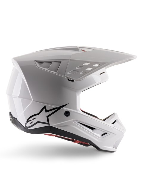 Alpinestars S-M5 Solid Helmet ECE 22.06, kask motocrossowy, biały błyszczący, profil boczny o kanciastym aerodynamicznym designie, wydatny daszek, zintegrowane otwory wentylacyjne, czarne logo Astars z tyłu i widoczna czerwona wyściółka wewnętrzna